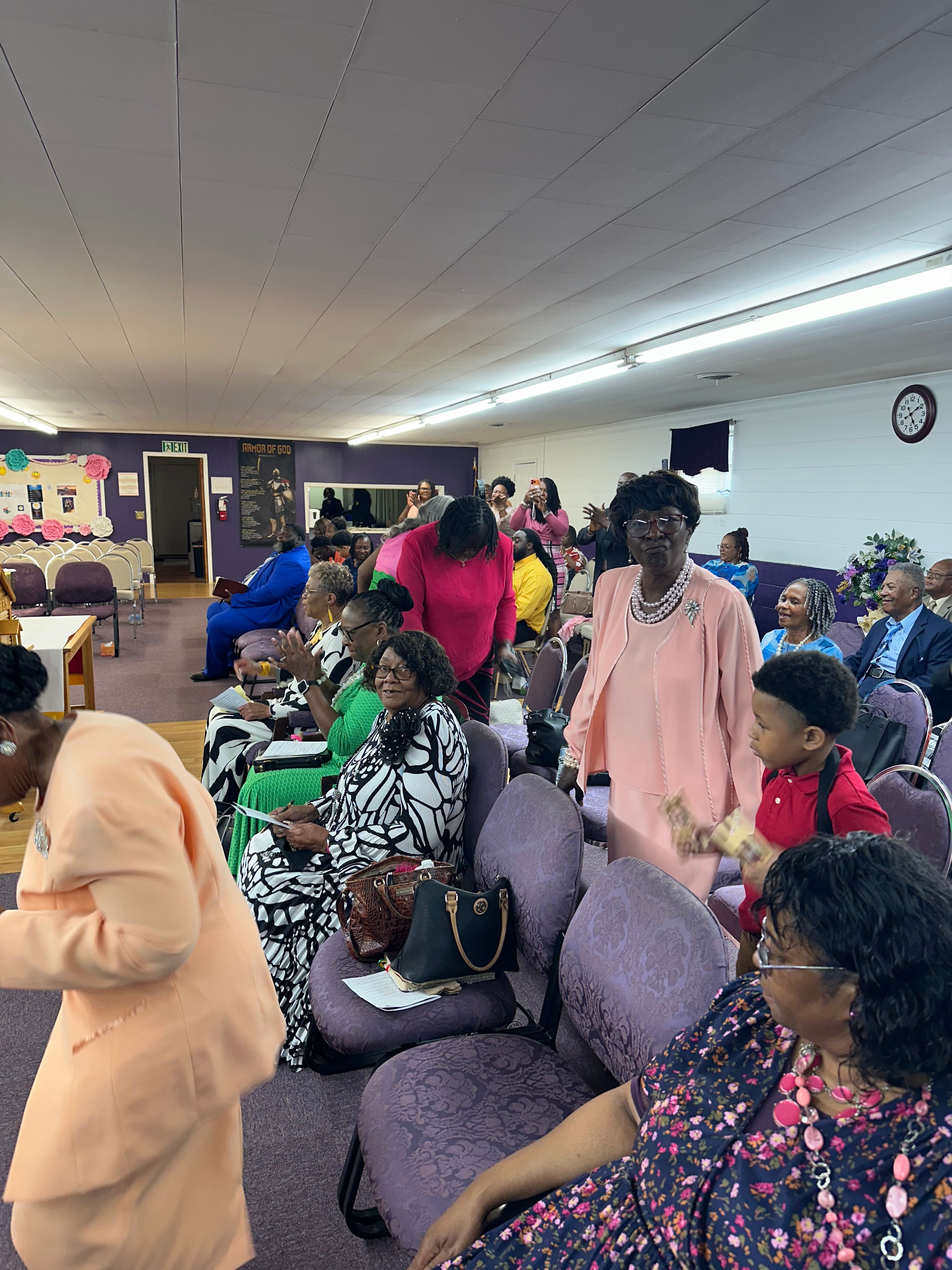 Congregation in colorful Sunday attire at HOAC
