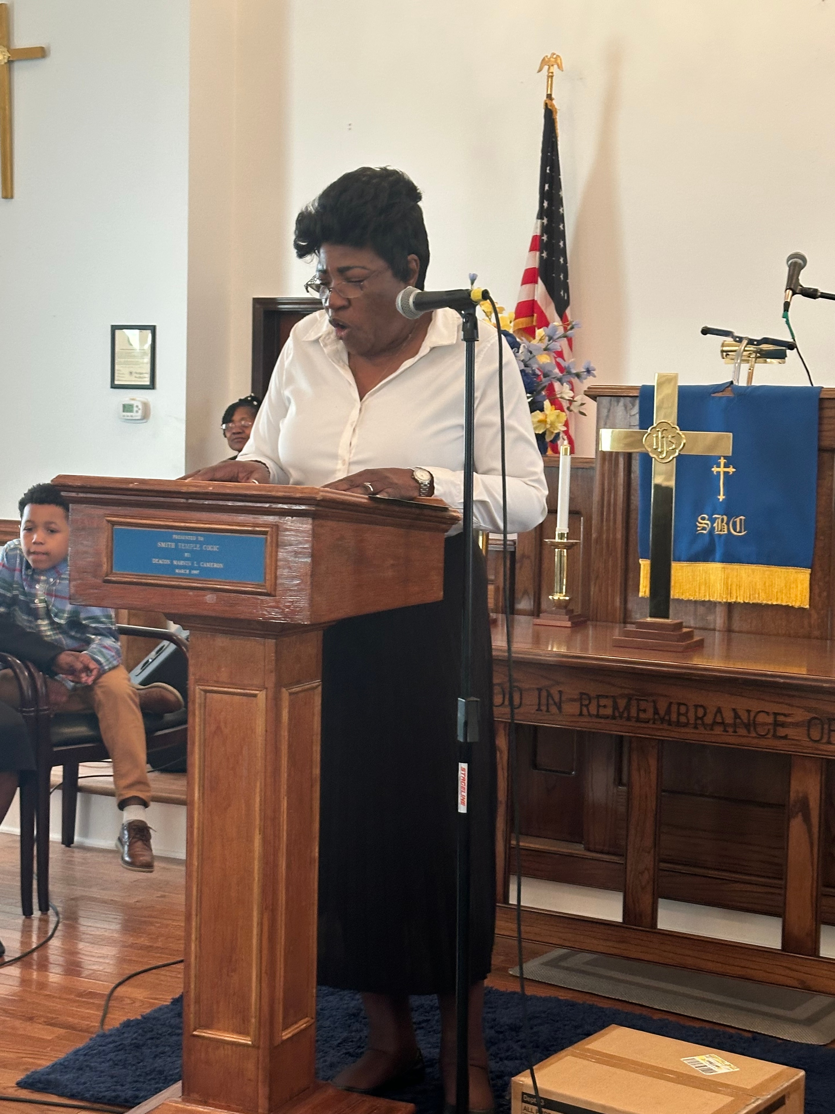 Woman in white at the pulpit during service at House of Another Chance COGIC